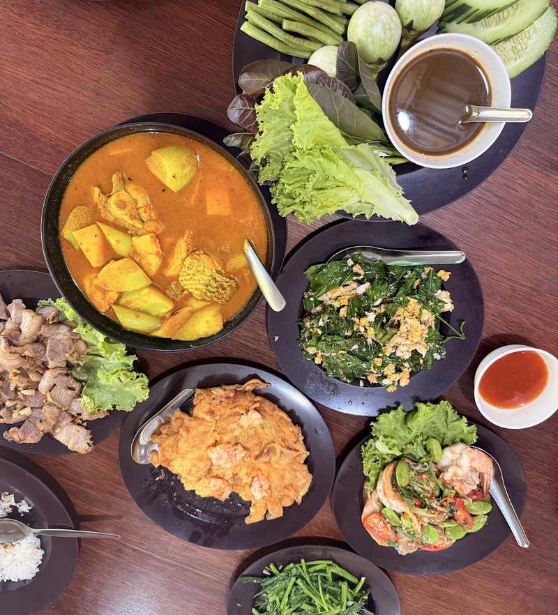 สำรับอาหารใต้เต็มโต๊ะ แกงเหลือง ผัดผัก ของทอด และผักเหนาะ